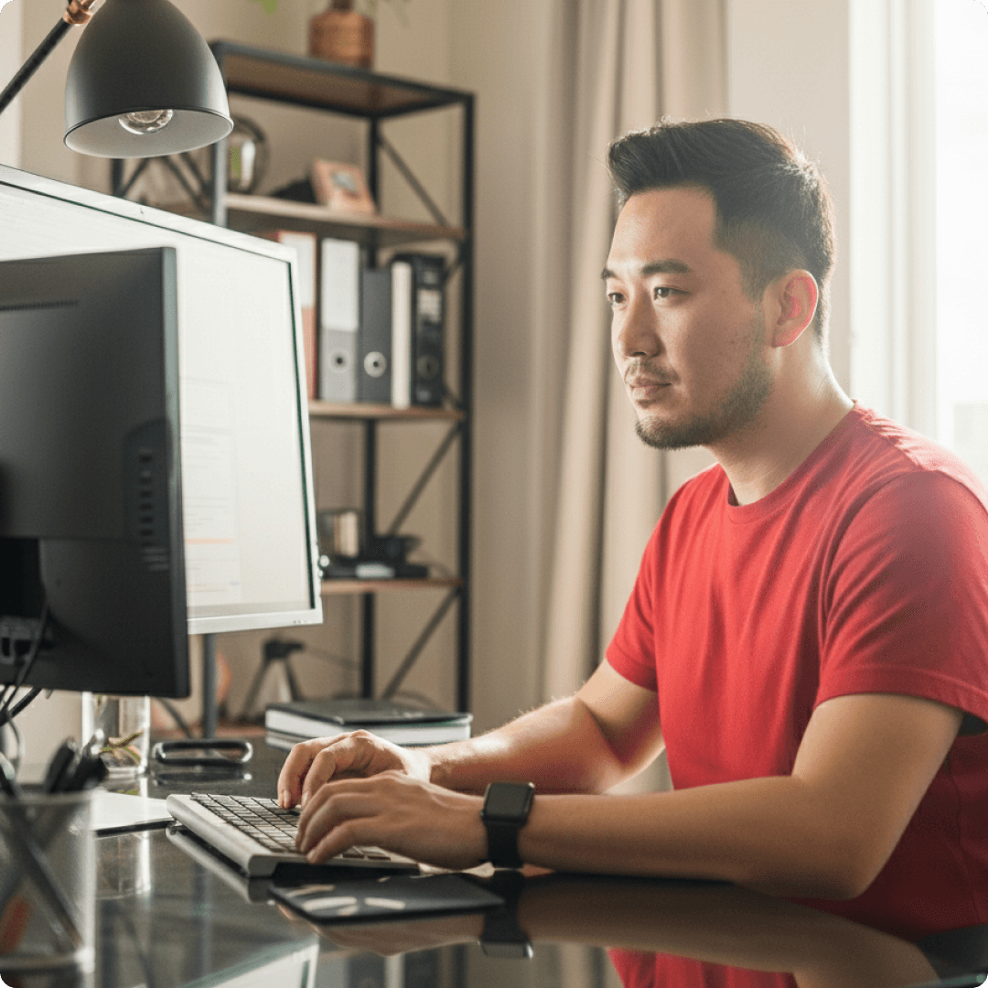 Man sitting at his desk focused on a computer screen, representing a professional comparing webinar software features and performance.